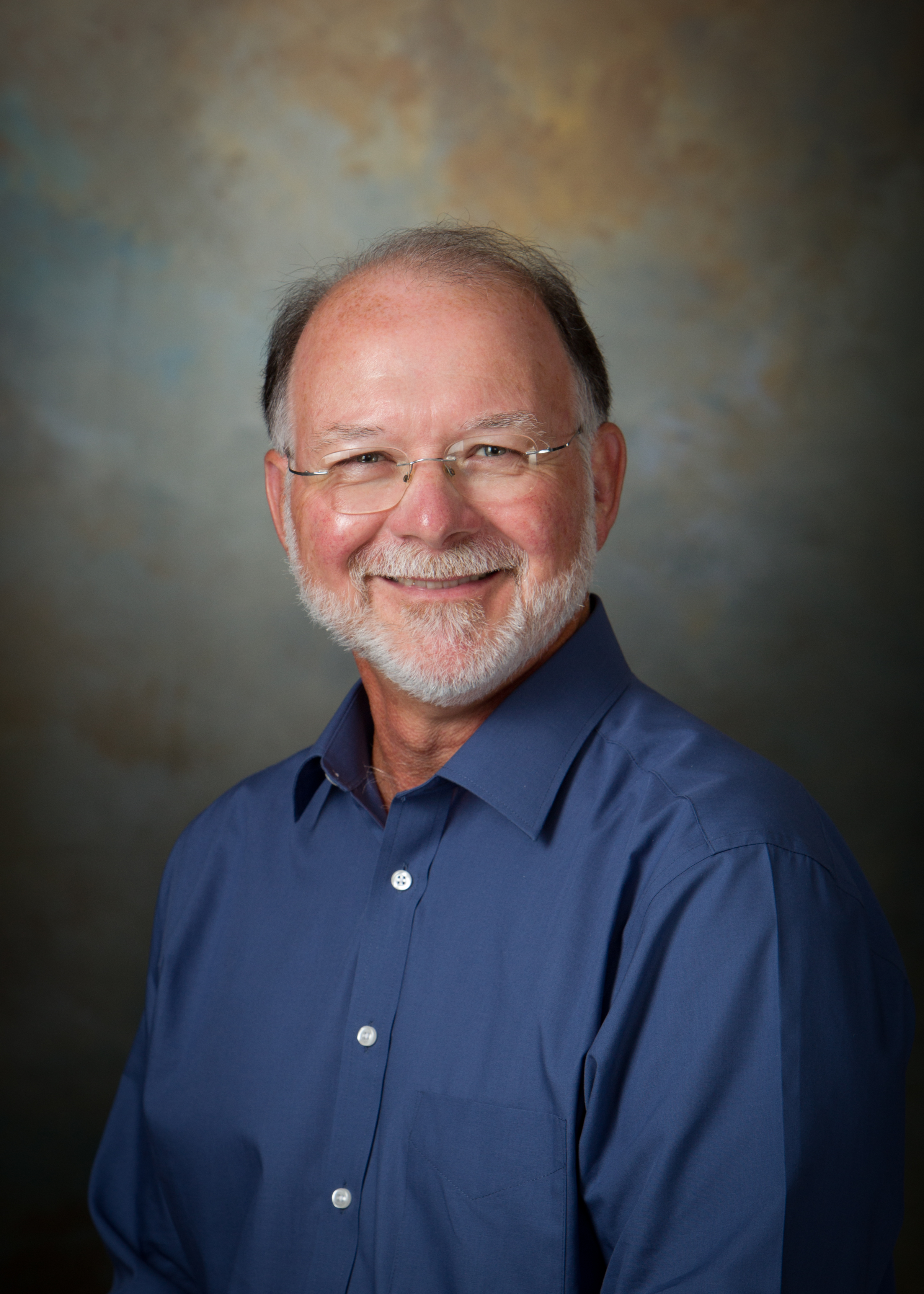 headshot of Tom Williams in a blue dress shirt